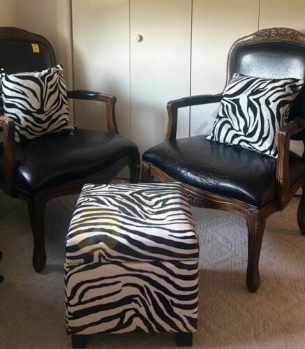 Wooden and Black Leather Chairs with Zebra Throw Pillows and a Zebra Storage Ottoman